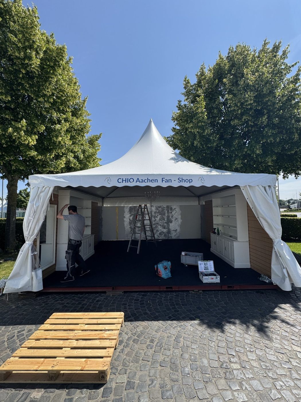 Aufbau eines Verkaufszelts für einen Event-Shop im Freien
